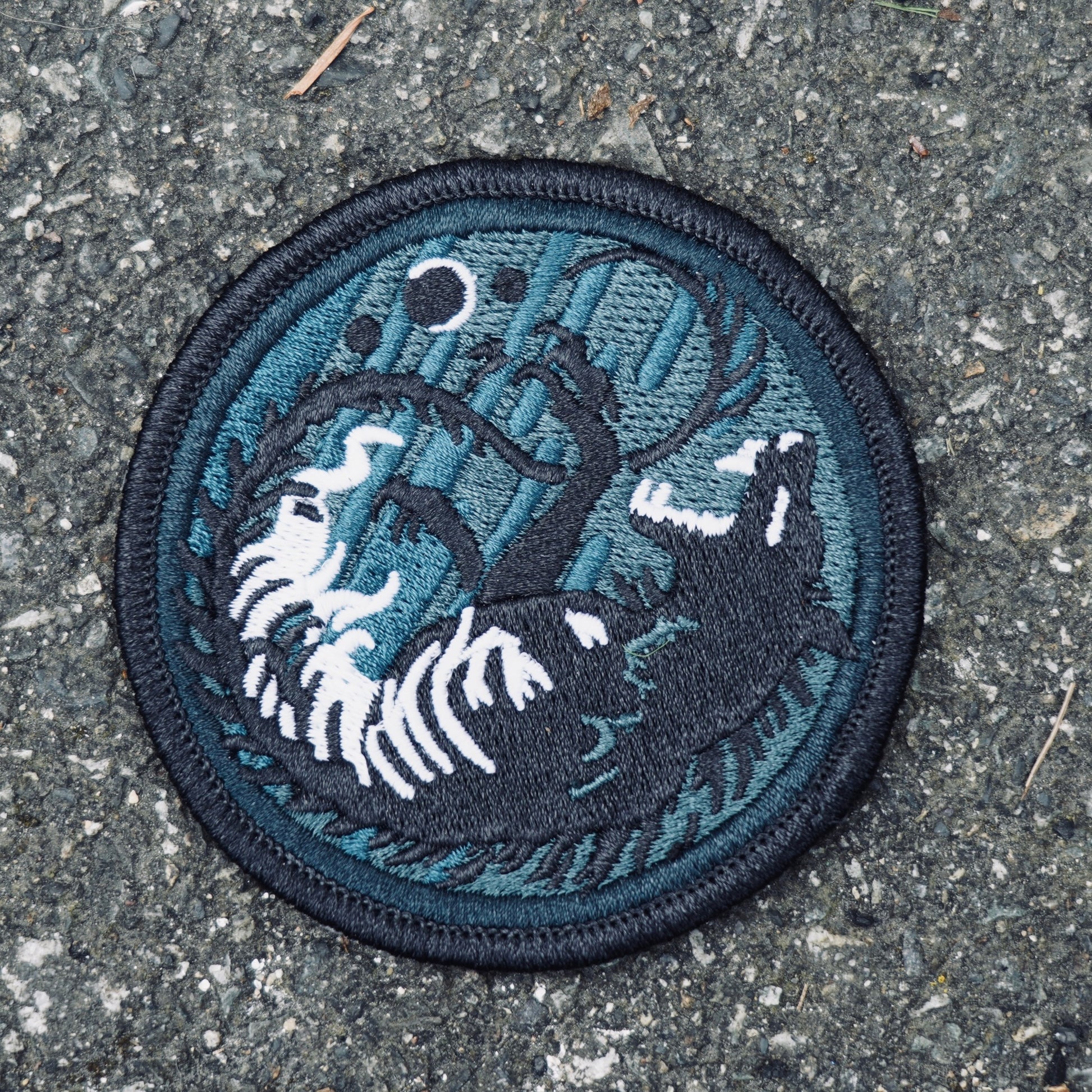 Embroidered patch of wolf chasing stages of the moon glow in the dark